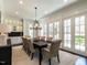 Bright dining room with modern chandelier, hardwood floors, and French doors leading to the outdoor area at 464 Rosemont Dr, Durham, NC 27713