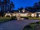 Beautiful home with manicured landscaping, a circular driveway, and elegant lighting at 464 Rosemont Dr, Durham, NC 27713