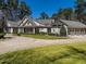 Expansive gray home with manicured lawn, circular driveway, and attached three-car garage against a backdrop of mature trees at 464 Rosemont Dr, Durham, NC 27713