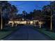 Elegant home with a long driveway and lush landscaping illuminated by streetlights at dusk at 464 Rosemont Dr, Durham, NC 27713