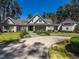 Stately gray home featuring manicured lawn, circular driveway, and lush landscaping against a backdrop of mature trees at 464 Rosemont Dr, Durham, NC 27713