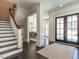 Elegant foyer featuring hardwood floors, grand staircase, and stylish double doors leading to the exterior at 464 Rosemont Dr, Durham, NC 27713