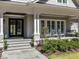 Charming front porch with rocking chairs, stylish front door, and meticulously maintained landscaping at 464 Rosemont Dr, Durham, NC 27713