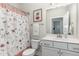 Well-lit bathroom featuring a floral shower curtain and white vanity at 49 Parkside Dr, Lillington, NC 27546