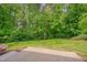 Well-maintained backyard featuring a lush lawn, mature trees, and a charming birdhouse, perfect for outdoor enjoyment at 504 Applecross Dr, Mebane, NC 27302
