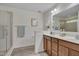 Bright bathroom featuring double sinks, wood cabinets, and a glass door shower at 504 Applecross Dr, Mebane, NC 27302