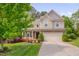 Charming two-story home with a well-manicured lawn, flowering shrubs, and an attached two-car garage at 504 Applecross Dr, Mebane, NC 27302