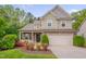Charming two-story home with a well-manicured lawn, flowering shrubs, and an attached two-car garage at 504 Applecross Dr, Mebane, NC 27302