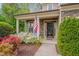 Inviting front porch with stone accents, decorated with flowers, and American flag at 504 Applecross Dr, Mebane, NC 27302