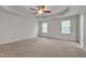 Spacious main bedroom with a tray ceiling, fan, and two windows to let in natural light at 504 Applecross Dr, Mebane, NC 27302
