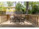 Back deck offers a cozy spot to unwind with a table and chairs, set against a backdrop of trees at 507 Canal St, Durham, NC 27701