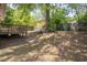 Large backyard with a wooden deck, a mature tree, and a full wood fence at 507 Canal St, Durham, NC 27701
