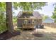 Backyard with a small wood deck, patio, lush tree, and string lights at 507 Canal St, Durham, NC 27701