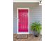 Close-up of the vibrant red front door with a fern and stylish welcome mat at 507 Canal St, Durham, NC 27701