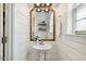 Charming powder room featuring shiplap walls, decorative mirror, and modern fixtures at 5172 Copain Cove, Fuquay Varina, NC 27526