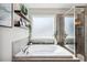 Spa-like bathroom with a soaking tub, glass shower, and decorative floating shelves at 5172 Copain Cove, Fuquay Varina, NC 27526