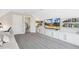 Bonus room featuring tv, built-in shelving, and a doorway leading to stairs at 5172 Copain Cove, Fuquay Varina, NC 27526