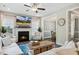 Cozy living room with fireplace, ceiling fan, hardwood floors, and adjacent dining room at 5172 Copain Cove, Fuquay Varina, NC 27526