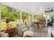 Bright sunroom featuring large windows, wood floors, and a ceiling fan with comfortable seating at 5172 Copain Cove, Fuquay Varina, NC 27526