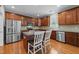 Modern kitchen with hardwood floors, stainless steel appliances, and brown cabinets at 5240 Holly Ridge Farm Rd, Raleigh, NC 27616