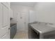 Well-lit laundry room boasts modern, front-loading washer and dryer, plus plenty of storage space at 5240 Holly Ridge Farm Rd, Raleigh, NC 27616