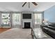 Cozy living room with fireplace, plush carpet, and many bright windows at 5240 Holly Ridge Farm Rd, Raleigh, NC 27616