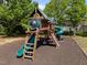 Wooden playground with slides, ladders, and a climbing wall set amidst lush green trees in the community at 5240 Holly Ridge Farm Rd, Raleigh, NC 27616