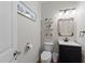 Stylish powder room featuring a dark vanity, decorative mirror, and charming decor at 5240 Holly Ridge Farm Rd, Raleigh, NC 27616