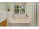 Bathroom featuring a soaking tub with tile surround and a window view at 5610 Picnic Rock Ln, Raleigh, NC 27613