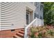 Inviting front entrance with brick steps, white railing and a charming exterior, enhanced by beautiful red roses at 5610 Picnic Rock Ln, Raleigh, NC 27613