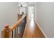 Hallway with hardwood floors, decorative railing, and views into adjacent rooms at 5610 Picnic Rock Ln, Raleigh, NC 27613