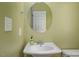 Cozy powder room featuring a pedestal sink with chrome hardware, a mirror, and light green wall at 5610 Picnic Rock Ln, Raleigh, NC 27613