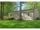 Home exterior boasts a wooden deck perfect for outdoor enjoyment, nestled amongst mature trees at 567 Howard Tant Rd, Zebulon, NC 27597