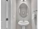 Bathroom features a pedestal sink, oval mirror, and neutral wall colors for a clean, minimalist look at 5701 Princess Curry Way, Raleigh, NC 27610