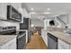 Modern kitchen featuring stainless steel appliances, granite countertops, and an open layout to the living room at 5701 Princess Curry Way, Raleigh, NC 27610