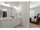 A minimalist bathroom with double sinks in white vanities, as well as natural light at 5803 Vintage Oak Ln, Raleigh, NC 27613