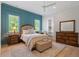 This bedroom features a blue accent wall, hardwood floors, and a ceiling fan at 5803 Vintage Oak Ln, Raleigh, NC 27613