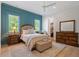 This bedroom features a blue accent wall, hardwood floors, and a ceiling fan at 5803 Vintage Oak Ln, Raleigh, NC 27613