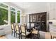 A dining room featuring large windows, a dark wood table, and china cabinet with stylish light fixture at 5803 Vintage Oak Ln, Raleigh, NC 27613