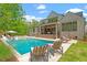 Stunning exterior showcasing pool, patio with fireplace, and lush green lawn at 5803 Vintage Oak Ln, Raleigh, NC 27613