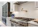 A gourmet kitchen featuring a stainless steel range with a pot filler and herringbone tile backsplash at 5803 Vintage Oak Ln, Raleigh, NC 27613
