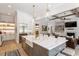 Open concept kitchen with island seating, modern appliances, and bright lighting at 5803 Vintage Oak Ln, Raleigh, NC 27613