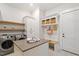 A well-organized laundry room with modern appliances, ample storage, seating, and a door at 5803 Vintage Oak Ln, Raleigh, NC 27613