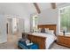 A spacious main bedroom featuring a wooden bed frame, bedside tables, and access to the bathroom at 5803 Vintage Oak Ln, Raleigh, NC 27613