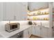 A well-organized pantry with white cabinets, open shelving, and stylish countertop appliances at 5803 Vintage Oak Ln, Raleigh, NC 27613