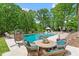 Charming outdoor patio with comfortable seating, lush greenery, and a view of the pool at 5803 Vintage Oak Ln, Raleigh, NC 27613
