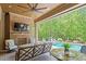 Inviting outdoor patio with a brick fireplace and view of the sparkling pool and lush greenery at 5803 Vintage Oak Ln, Raleigh, NC 27613