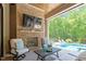 Relaxing covered patio with brick fireplace, cozy seating, and view of the refreshing pool at 5803 Vintage Oak Ln, Raleigh, NC 27613