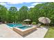 Inviting pool area with jacuzzi, lounge chairs, and lush landscaping perfect for relaxation at 5803 Vintage Oak Ln, Raleigh, NC 27613