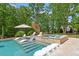 Beautiful pool with tanning ledge, jacuzzi, and lounge chairs surrounded by lush landscaping at 5803 Vintage Oak Ln, Raleigh, NC 27613